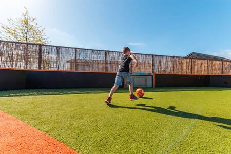 Kind spielt Fußball auf dem Spielfeld des Ferienparks EuroParcs Veluwemeer
