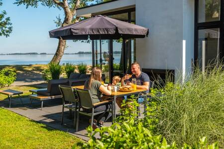 Familie beim Essen im Garten eines Ferienhauses im Ferienpark Europarcs Bad Hoophuizen