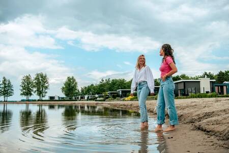 2 Frauen im Wasser vor Ferienhäusern im Ferienpark Europarcs Bad Hoophuizen
