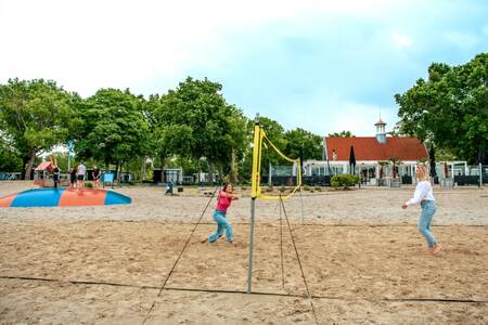Leute, die Volleyball spielen, und Kinder auf einem Lufttrampolin im Europarcs Bad Hoophuizen