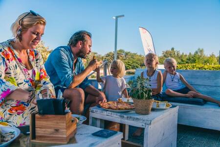 Familie beim Essen auf der Terrasse des Restaurants im EuroParcs Ferienpark EuroParcs Zilverstrand