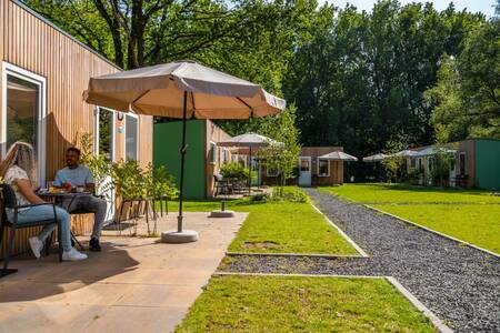 Ein Paar sitzt im Garten eines Chalets im Ferienpark Europarcs Het Amsterdamse Bos