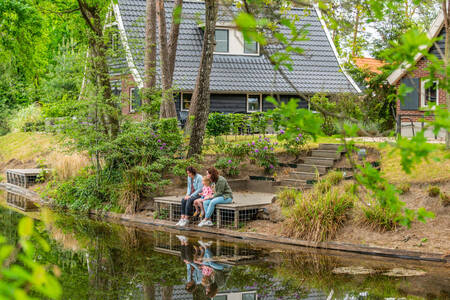 Familie auf einem Steg eines Ferienhauses im Ferienpark EuroParcs de Zanding