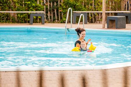 Frau mit Kind schwimmt im Freibad des Ferienparks Leukermeer