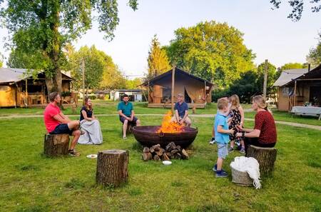 Menschen um ein Lagerfeuer an der Feuerstelle im Ferienpark Sandberghe