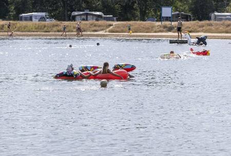 Kinder spielen mit Schlauchbooten auf dem See im Ferienpark Witterzomer