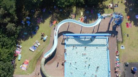 Luftaufnahme von Menschen im Freibad und große Rutsche im Ferienpark Witterzomer