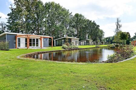 Ferienhäuser rund um einen Teich im Ferienpark De Lochemse Berg