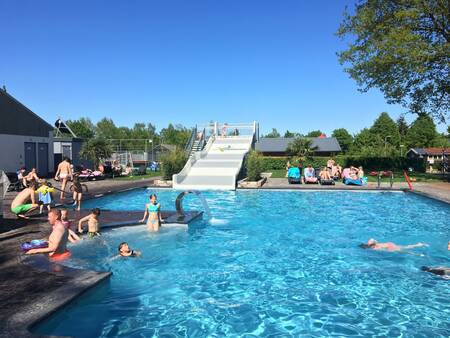 Menschen schwimmen im Außenpool des Ferienparks 't Rheezerwold