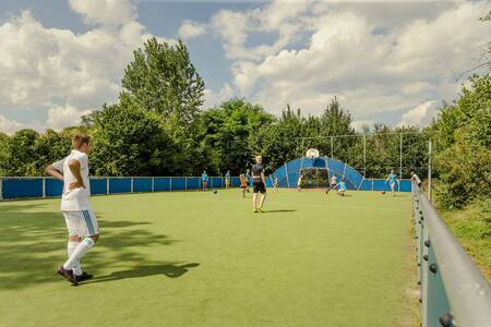 Fußballspielende Kinder auf dem Allwetter-Sportplatz des Ferienparks Mölke