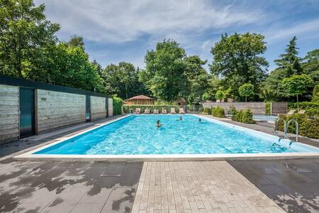 Menschen schwimmen im Außenpool des Bungalowparks Het Verscholen Dorp