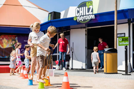 Kinder spielen vor dem Spielzimmer Chiliz im Ferienpark Kampeerdorp de Zandstuve