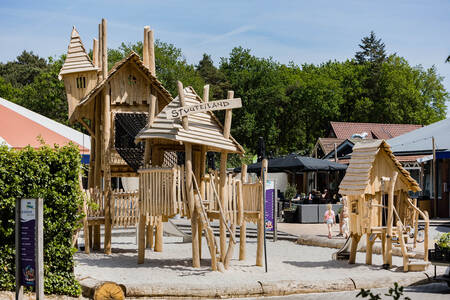 Ein Spielplatz mit Holzspielgeräten im Ferienpark Kampeerdorp de Zandstuve