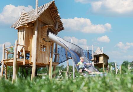 Kind auf einer Rutsche auf einem Spielplatz im Ferienpark Krieghuusbelten