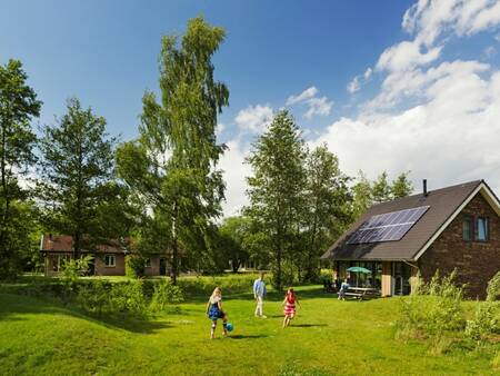 Kinder spielen im Garten eines Ferienhauses im Ferienpark Landal Aelderholt