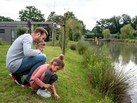 Familie am Wasser neben einem Ferienhaus im Ferienpark Landal Amerongse Berg