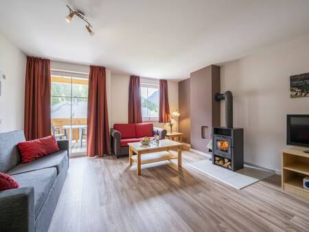 Wohnzimmer mit Holzofen einer Ferienwohnung im Ferienpark Landal Bad Kleinkirchheim