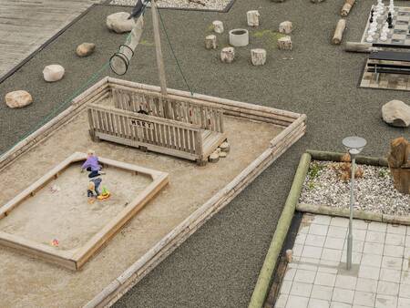 Kind spielt in einem Sandkasten auf dem Spielplatz im Landal Beach Park Ebeltoft