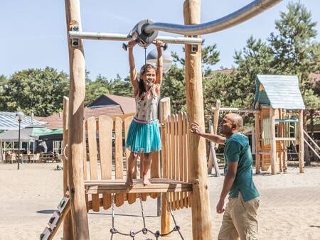 Eine Familie spielt auf dem Spielplatz im Ferienpark Landal Coldenhove