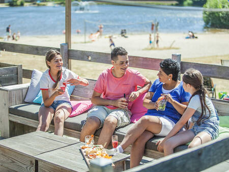 Familie auf einer Terrasse am Naturpool im Ferienpark Landal Domein de Schatberg