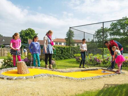 Familie spielt Golf auf dem Minigolfplatz des Ferienparks Landal Duc de Brabant