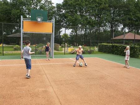 Kinder spielen Fußball auf dem multifunktionalen Sportplatz im Ferienpark Landal Duc de Brabant