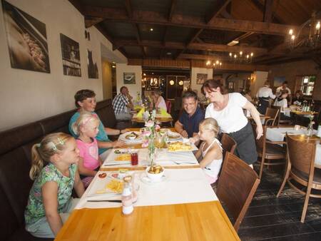 Familie am Tisch im Restaurant Auberge De Hilver im Ferienpark Landal Duc de Brabant