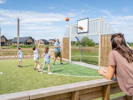 Kinder spielen auf dem multifunktionalen Sportplatz im Ferienpark Landal Elfstedenhart