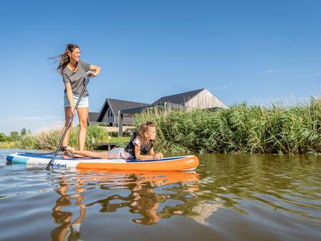 Mutter und Tochter paddeln auf einem Kanal im Ferienpark Landal Elfstedenhart