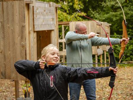 Vater und Tochter schießen im Landal Ferienpark Søhøjlandet Bogen