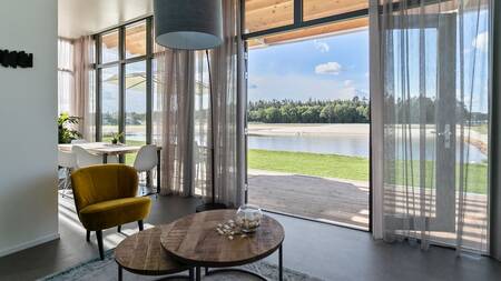 Wohnzimmer mit großen Terrassentüren zum Garten im Landal Ferienpark Sallandse Heuvelrug