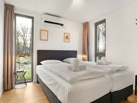 Schlafzimmer mit einem luxuriösen Doppelbett im Landal Ferienpark Sallandse Heuvelrug