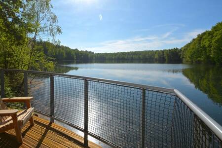 Balkon eines Ferienhauses mit Blick auf das Wasser im Landal Forest Resort Your Nature