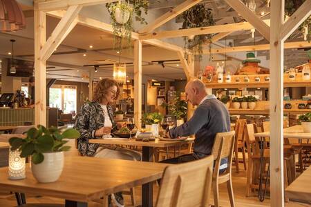 Paar isst im Restaurant De Brasserie im Ferienpark Landal Heihaas