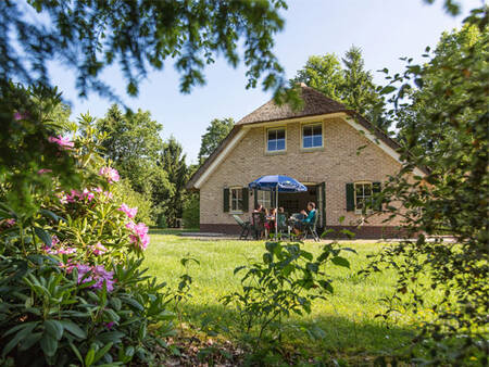 Familie in einem großen Garten eines Ferienhauses bei Landal Het Land van Bartje