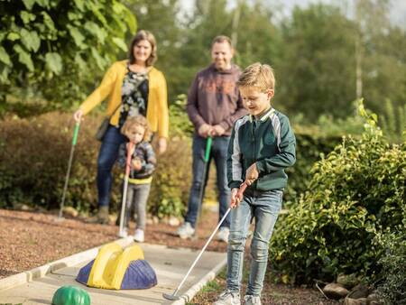 Die Familie spielt Golf auf dem Minigolfplatz des Ferienparks Landal Hunerwold State