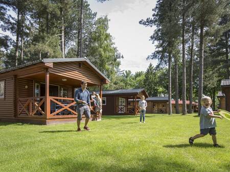 Familie spielt auf dem Rasen der Chalets im Ferienpark Landal Mooi Zutendaal