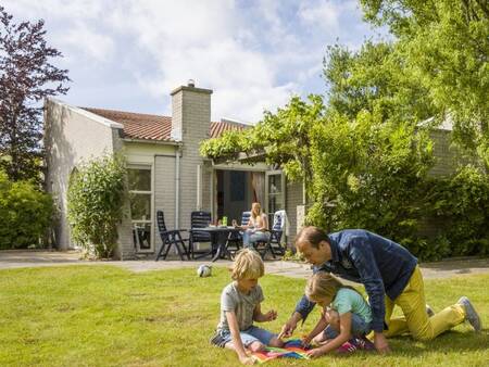 Familie spielt im Garten eines Ferienhauses im Ferienpark Landal Port Greve