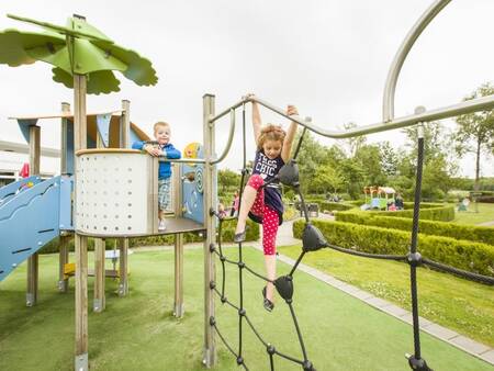 Kinder klettern auf einem Spielplatz im Ferienpark Landal Resort Haamstede