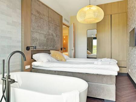 Schlafzimmer mit Bad einer Wohnung in Landal Résidence Westduin