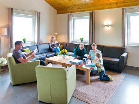 Wohnzimmer mit Familie in einem Ferienhaus im Ferienpark Landal Salztal Paradies