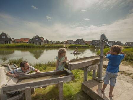 Eine Familie spielt auf dem Wasserspielplatz im Ferienpark Landal Strand Resort Nieuwvliet-Bad