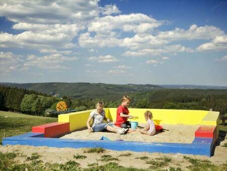 Kinder spielen im Sandkasten auf dem Spielplatz des Ferienparks Landal Village les Gottales