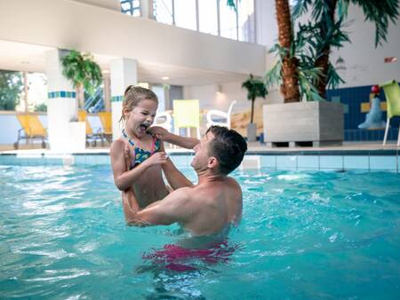 Vater und Tochter schwimmen im Hallenbad von Landal Vitamaris