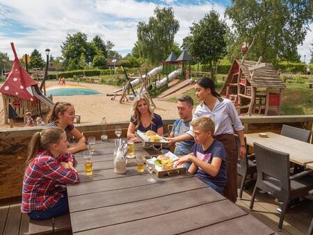 Genießen Sie die Sonne auf der Terrasse des Café-Bistro Woods im Ferienpark Landal Warsberg