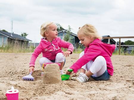 Kinder spielen im Sand am Erholungsstrand des Ferienparks Landal Waterpark Sneekermeer