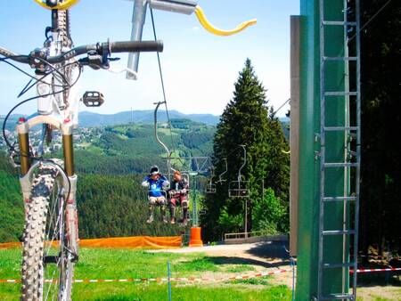 Landal Winterberg - 2 Personen und ein Mountainbike in einem Sessellift