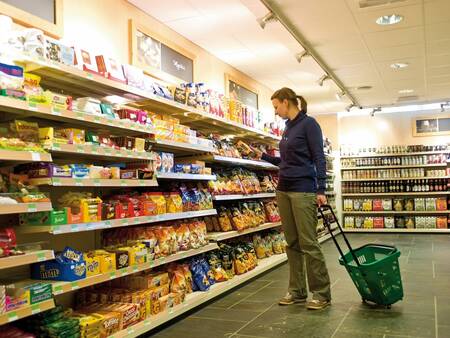 Frau kauft im Supermarkt des Ferienparks Landal Winterberg ein