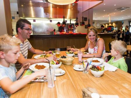 Familie speist im Restaurant des Ferienparks Landal Wirfttal