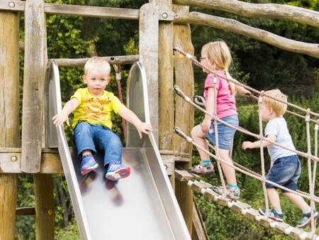 Kinder auf einem Spielgerät auf einem Spielplatz im Ferienpark Landal Wirfttal